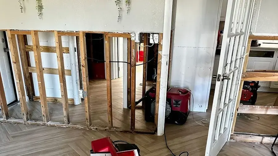 Walls opened to the studs with a dehumidifier drying a room in an El Cerrito home after a water leak