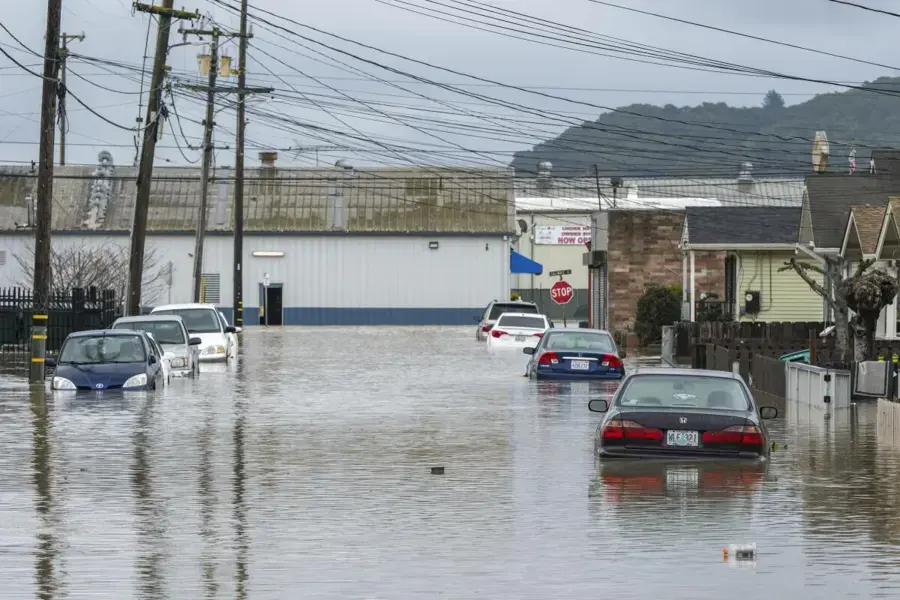 Cars standing in floodwater on a street after a winter atmospheric river storm